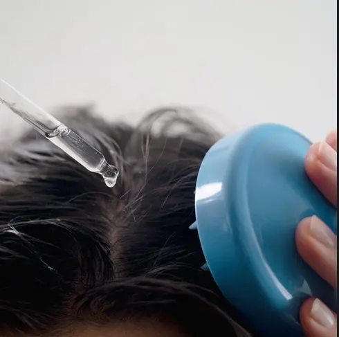 Minoxidil application with a hair scrubber