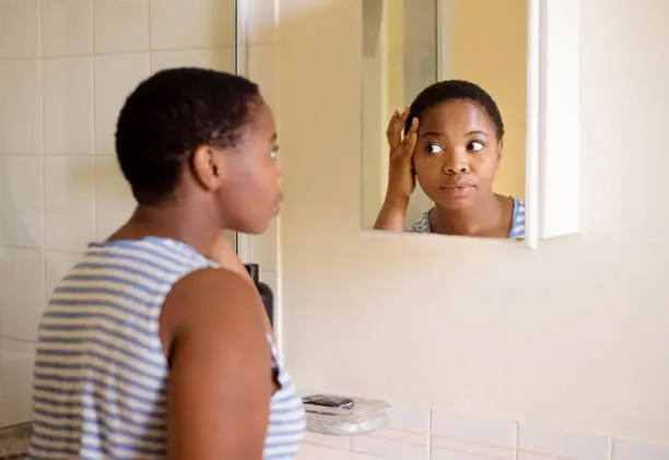 a woman looking at her reflection in a mirror
