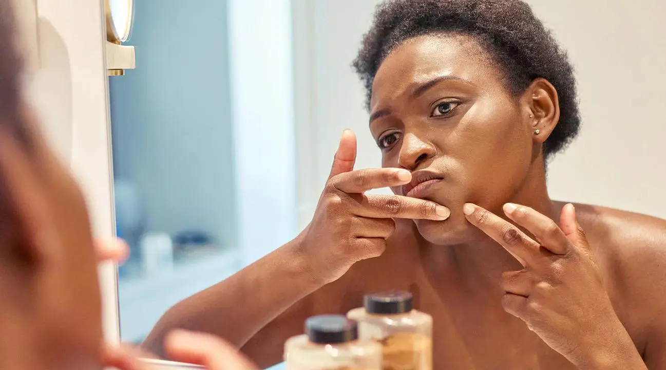 a woman pointing her fingers at her face