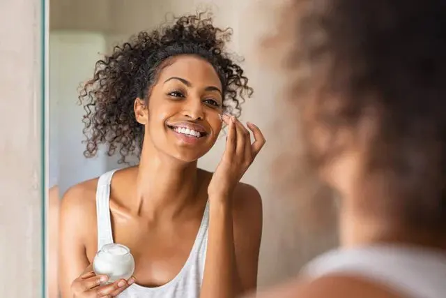 a in her second trimester putting cream on her face