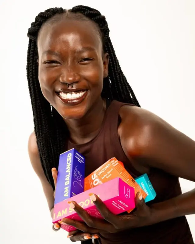 A woman holding some uncover skincare products