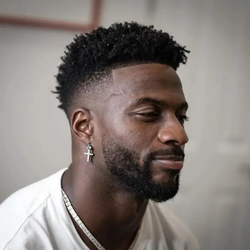 a man with a beard and a cross earrings