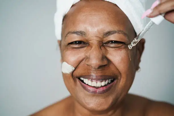 A woman with a wrinkle face applying serum on her face
