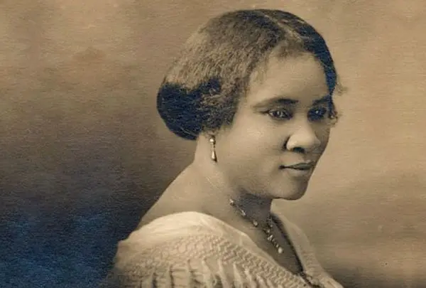 a woman with short dark hair wearing a necklace and a necklace